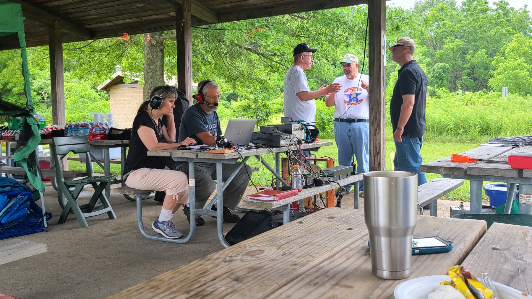 Bill (KD9WEW) operating the GOTA station while Loren (K3RFC) and Glenn (K9GLA)  discusses amateur radio with visitors